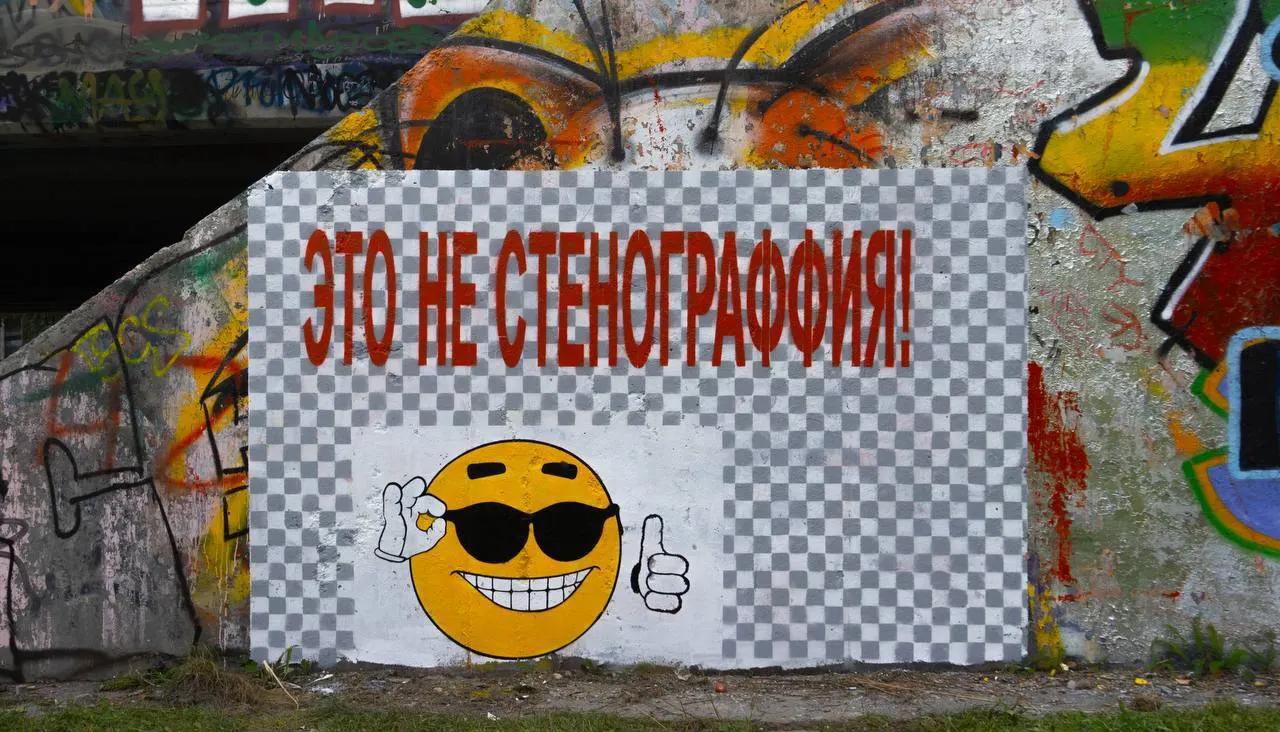 Неизвестный художник создал граффити возле моста на улице Московской в Екатеринбурге; местные обсуждают, связано ли произведение с фестивалем «Стенография».